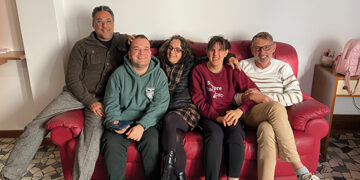 Da sinistra, Alberto De Tata di Mea Scs, Tommaso con mamma Cosetta Gonzato e Nicole con papà Massimo sul divano di casa
